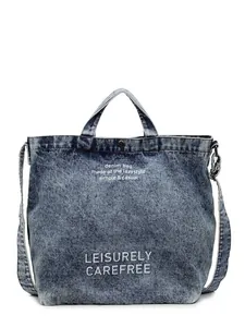 Minimalistische Schultertasche aus gewaschenem Denim mit weißem Schriftzug in Blau