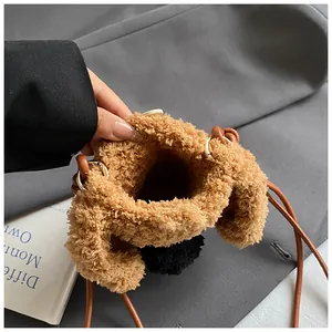 Détail d'un sac seau en peluche pour femme avec texture douce et bandoulière en cuir