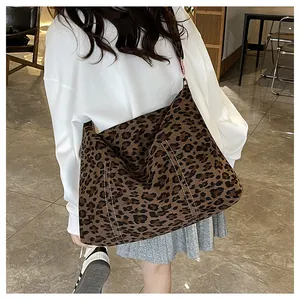 Dettaglio della borsa tote in tela leopardata con cuciture a contrasto e tracolla