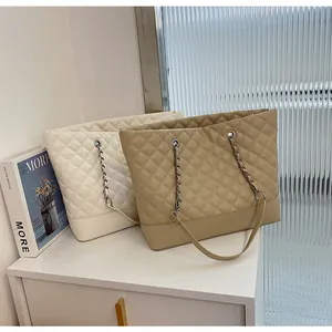 Close-up of quilted tote bag with leather-interwoven chain strap and reinforced base