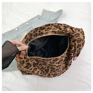 Dettaglio della borsa leopardata con cerniera dorata e manici in pelle marrone