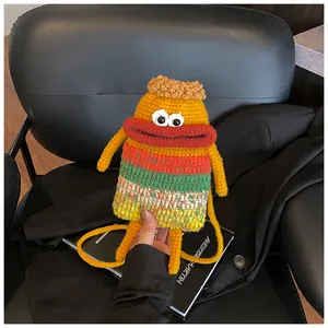 Détail d'un sac à bandoulière en tricot monstre jaune avec de grandes lèvres rouges