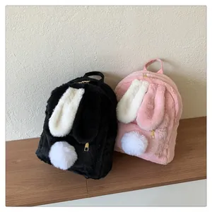 Close-up of fuzzy bunny ears and pom-pom tail detail on plush backpacks in black and pink