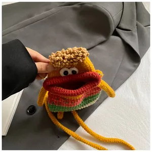 Détail d'un sac monstre jaune crocheté à la main avec lèvres rouges et texture tricot