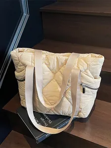 Minimalist beige quilted tote bag with rhombus stitching on a wooden stairs background