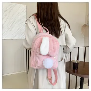 Detail of pink plush rabbit backpack showing fuzzy texture, bunny ears, and pom-pom tail