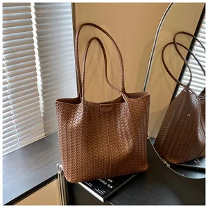 Detailed view of the brown woven leather texture on a large trapezoidal tote bag