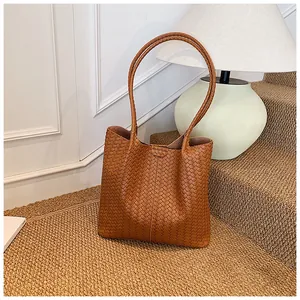 Close-up of premium brown woven leather texture on a spacious commute tote bag