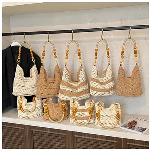 Detail of hollow woven tote bag with wooden bead handle and bohemian knit texture