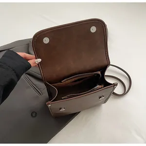 Interior detail of vintage brown leather bag with dual zipper pockets and magnetic snap
