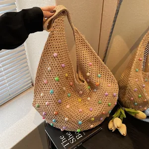 Close-up of woven tote bag with colorful beads and wide shoulder strap detail