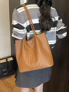Brown woven leather tote bag with dual shoulder straps shown on a model for daily commute