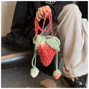 Detail of handmade crochet strawberry bag showing textured knit and strawberry seed pattern