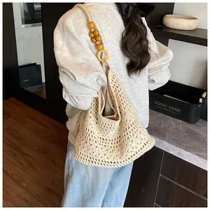 Detail of hollow woven tote bag featuring unique wooden bead shoulder straps and inner lining