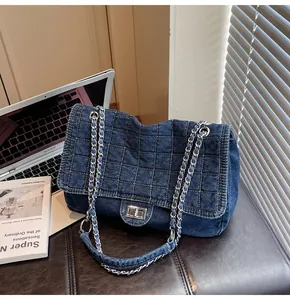 Macro shot of square quilted denim texture and silver twist lock on shoulder bag