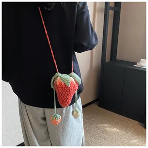 Close-up of handmade crochet strawberry mini crossbody bag with 3D knitted texture
