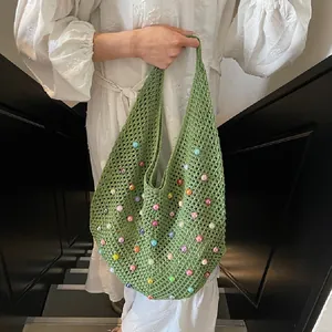 Detail of green knit beach tote bag with colorful acrylic beads and hollow mesh texture
