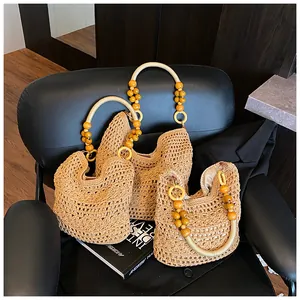 Detail of woven straw tote bags in two sizes with decorative yellow beaded handles
