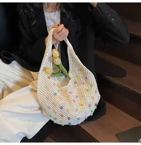 Detail of white knit tote bag with multicolored beads and floral interior decoration