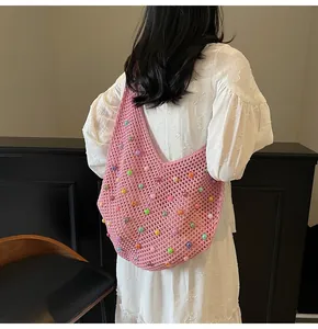 Detailed knit texture of pink woven shoulder bag with colorful bead decorations