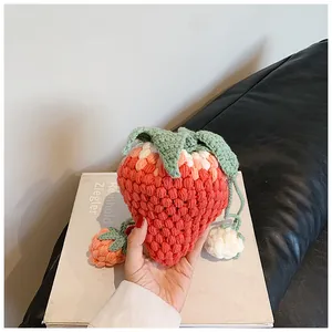 Detailed close-up of a handmade crochet strawberry drawstring bag held in hand