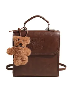 Vintage brown PU leather backpack for women with embossed letters and plush bear charm