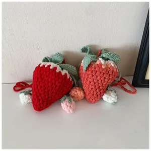 Close-up of handmade crochet strawberry bags showing red and pink knitted textures