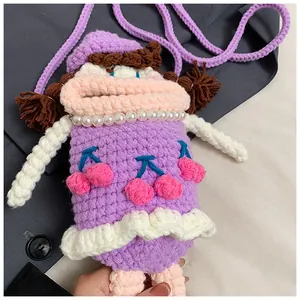 Dettaglio borsa viola all'uncinetto con bocca a salsiccia, collana di perle e ciliegie blu