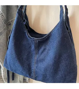 Detail of blue denim tote bag featuring yellow double stitching and soft fabric texture