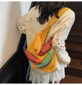 Detail of yellow knit mesh tote bag with colorful fish charms and textured weave strap