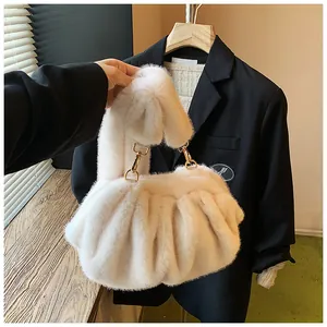 Detailweergave van zachte witte imitatiebont cloud tas en elegante goudkleurige hardware