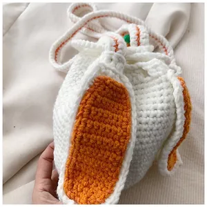Détail de la texture d'un sac au crochet blanc avec oreilles de lapin et carotte