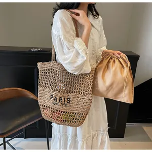 Vue détaillée élégante du sac cabas de plage en paille tressée avec un beau design en filet.