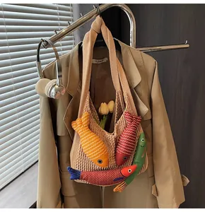 Close-up of beige knit tote bag featuring colorful 3D fish charms and mesh texture