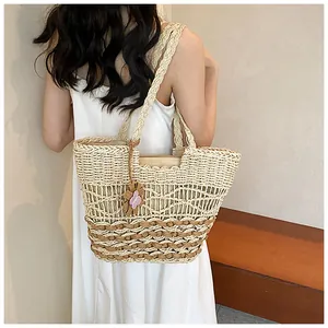 Dettaglio della borsa tote in paglia intrecciata con motivo a onde e fiore rosa