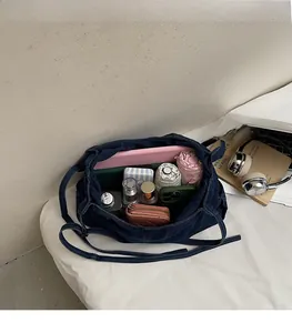 Top view of large capacity dark blue denim bag filled with daily essentials showing inner space
