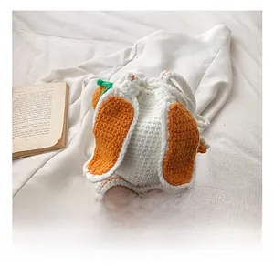 Détail d'un sac à cordon tricoté main avec oreilles de lapin et motifs de carottes