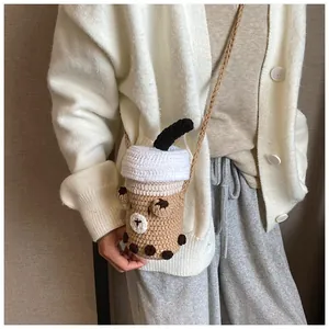 Dettaglio ravvicinato della borsa a tracolla in maglia a forma di bubble tea con orso