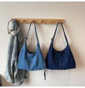 Detail showing contrast between light and dark blue denim tote bags on wooden hooks