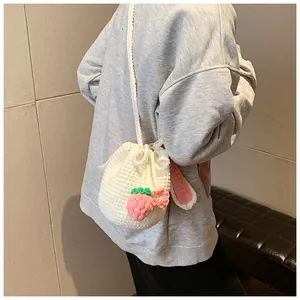 Détail d'un sac seau fait main au crochet avec oreilles de lapin et fraises