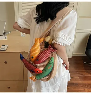 Detail of beige knitted tote bag featuring four colorful fish plush doll decorations