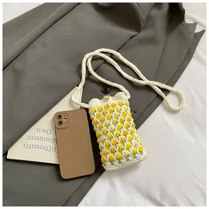 Detail of hand-crocheted tulip crossbody bag with 3D floral pattern and wooden button closure