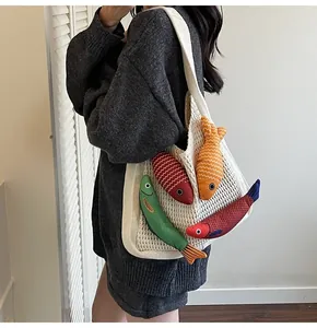 Detail of white handmade crochet tote bag with creative colorful 3D fish plush charms