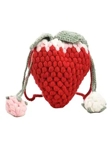 Handmade crochet strawberry crossbody bag with green leaf detail on a white background