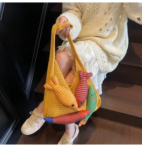 Detailed knit texture of a yellow crochet tote bag featuring colorful 3D fish appliques