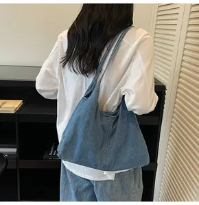 Detailed back view of a large washed denim hobo bag featuring slim double shoulder straps
