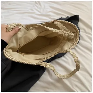 Dettaglio borsa tote in paglia con fodera beige, tasca con zip e manici in corda spessa
