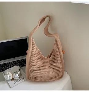 Detailed close-up of a beige knit tote bag showing intricate crochet mesh and rib textures