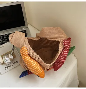 Macro shot of khaki hollow knit tote bag featuring colorful stuffed fish decorations