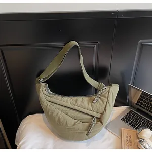 Detail of olive green crescent bag showing textured canvas and nylon crossbody strap